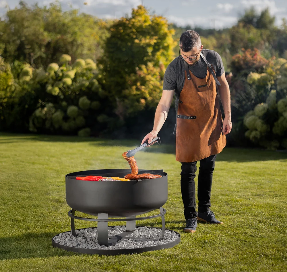 Man grilling on a COOK KING fire bowl